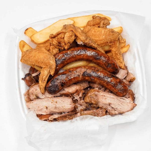 Sunny's Bar B Que combo with fried chicken wings, sausages, pulled pork, and potato wedges.